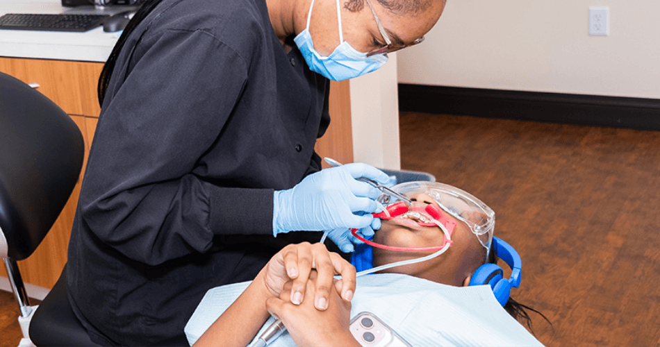 Child getting braces adjusted by Rodeo Dental orthodontist