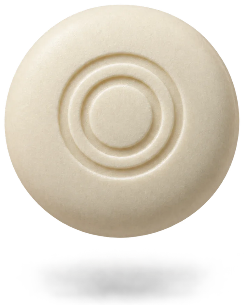 A round cream-coloured breath mint with the OneOral ring pressed into it