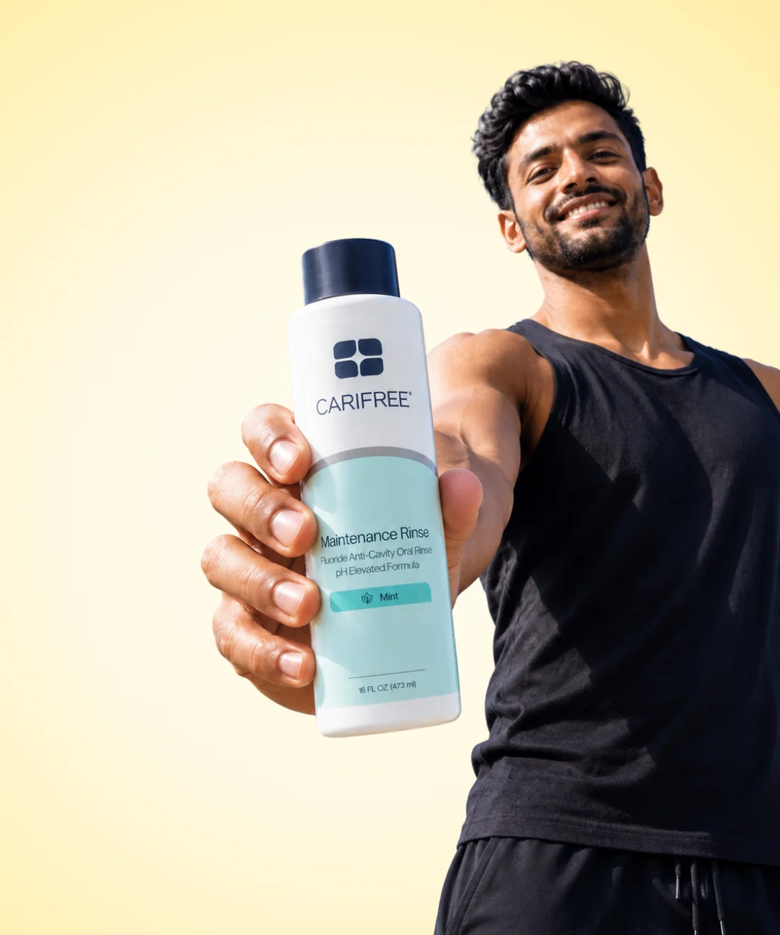 A member holding out a bottle of anti-cavity rinse